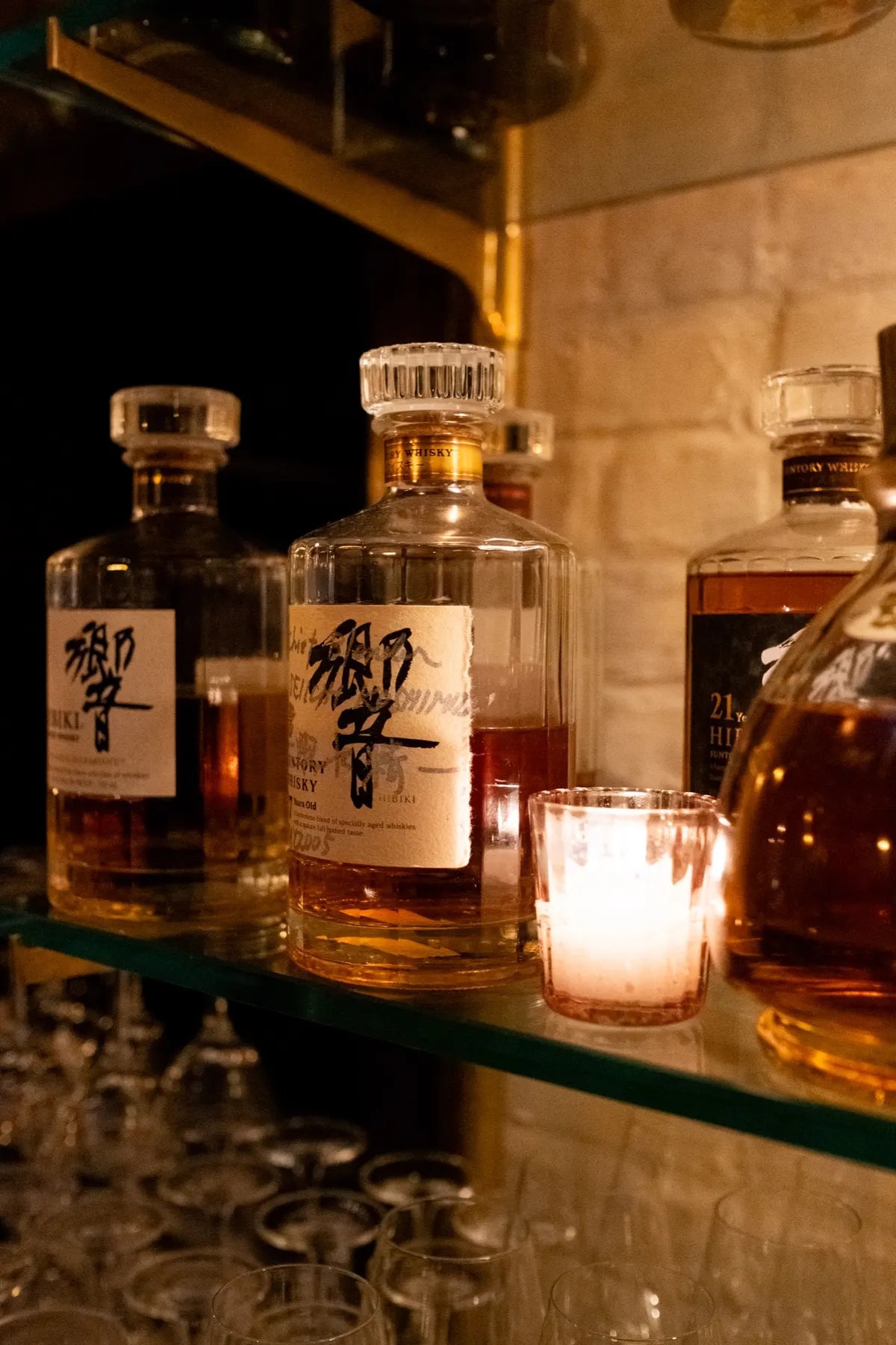 Hibiki whisky and a candle on the bar shelf