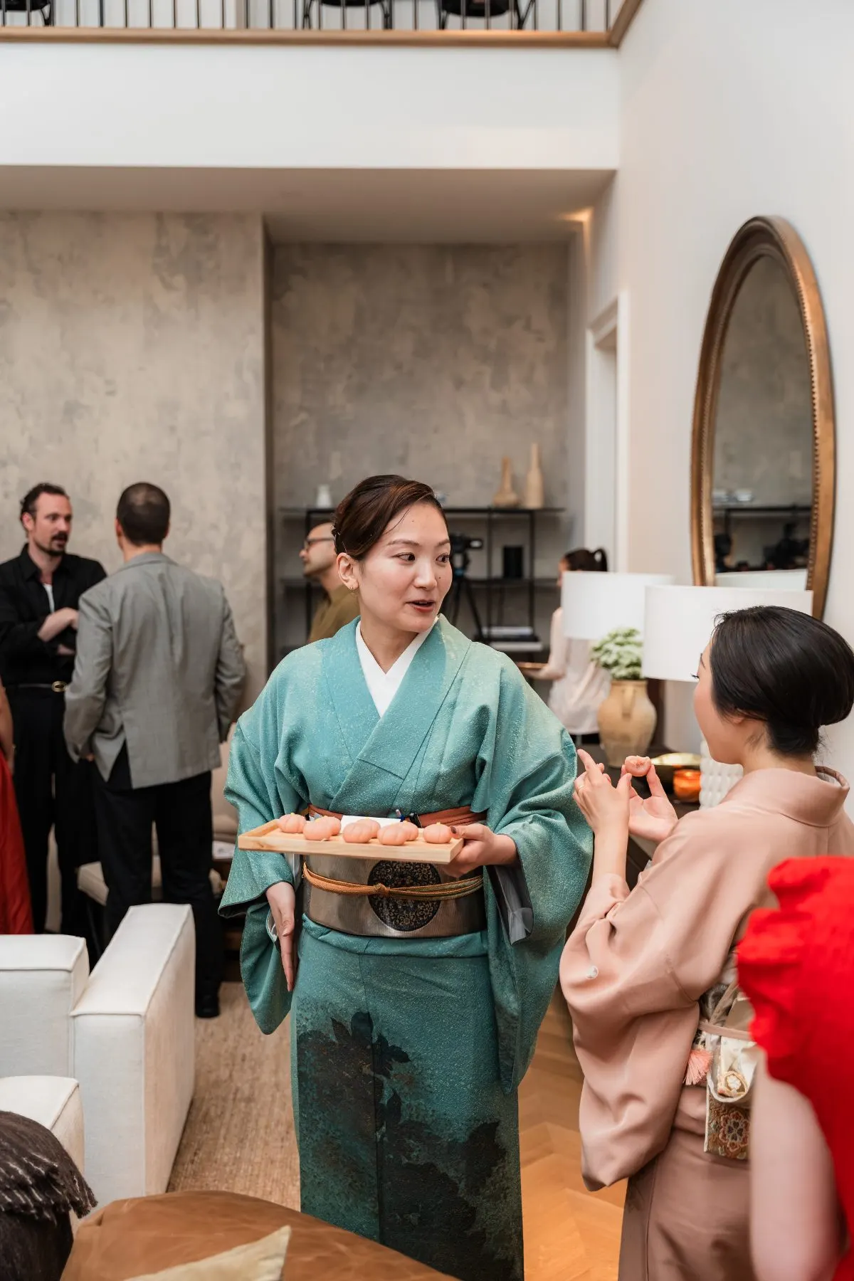 A host in kimono serving sweets