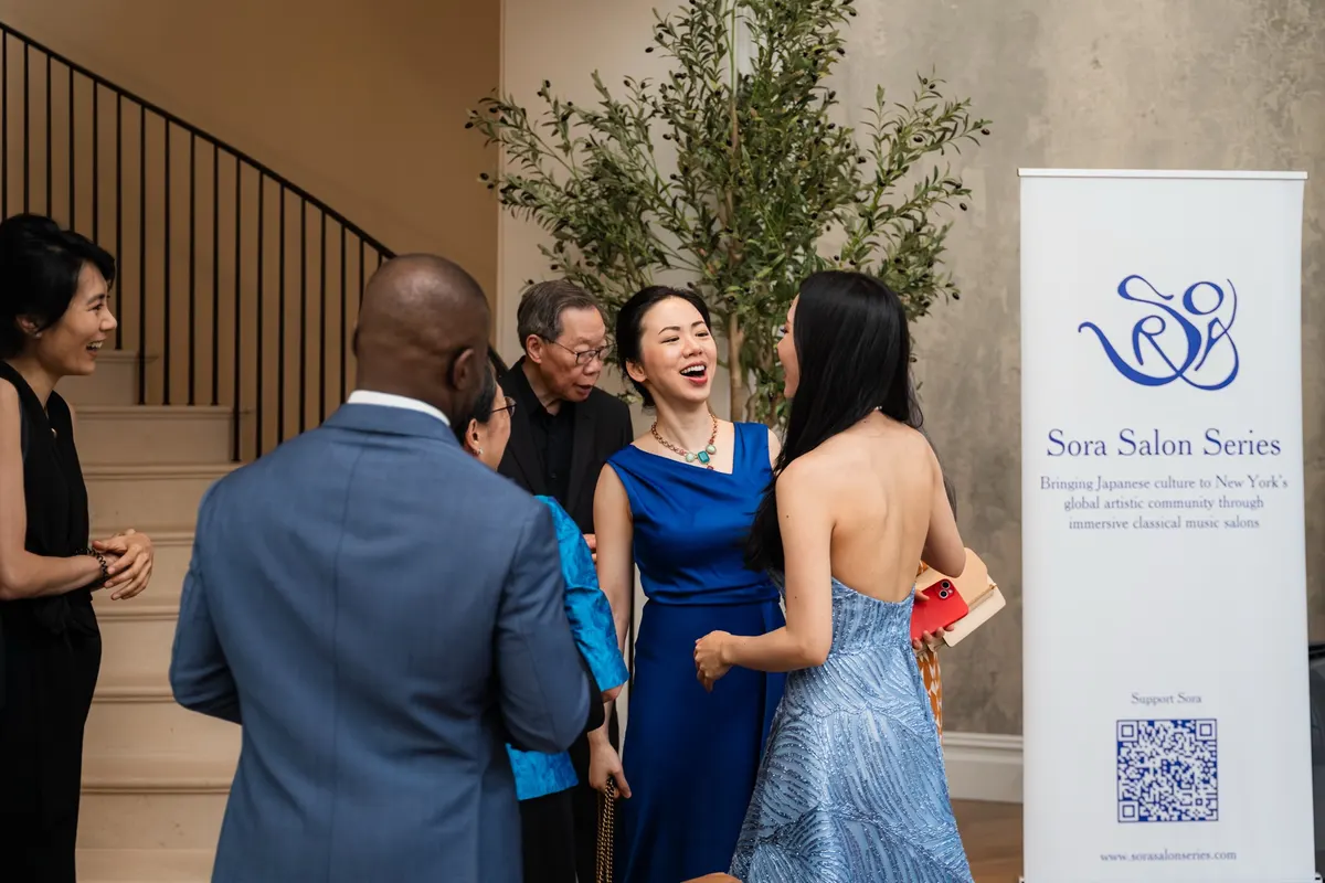 Guests laughing with the musicians by the staircase